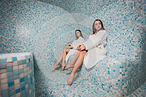 Young woman in white foam in a beautiful hamam of mosaic.