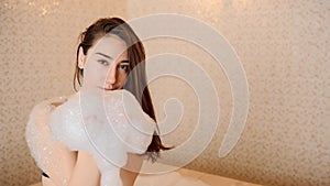 photo of a young woman in white foam relaxing in a hamam