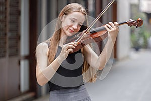 Young woman with white hair and blonde hair playing violin. beautiful musician female performer instrument play music