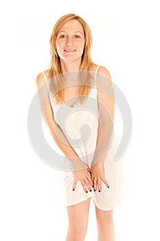 Young woman in white nightie protecting her pubes