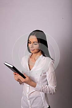 A young woman in a white shirt on white background. Careerist, business portrait