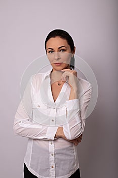 A young woman in a white shirt on white background. Careerist, business portrait