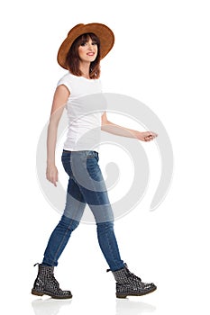 Young Woman In White T-Shirt And Hat Is Walking And Looking At Camera