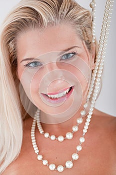 Young woman with white teeth and pearls