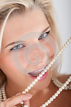 Young woman with white teeth and pearls