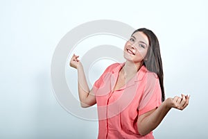 Young woman on white wall enjoy dancing while listening to music at a party