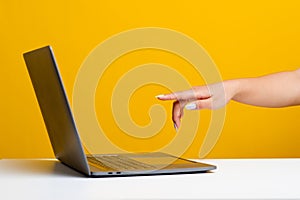 Hands and laptop of a young woman who is determined to work in the online errands hand pointing to computer in front Wan on the photo