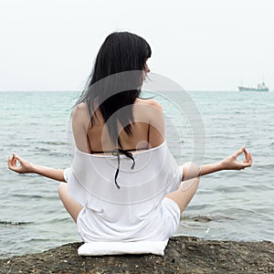 Young woman on wild rocky seashore