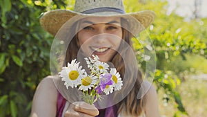 Young woman with wildflowers in her hands