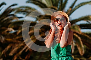 Young woman in the wind by the palm trees