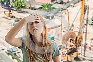 A young woman by the window annoyed by the building works outside. Noise concept