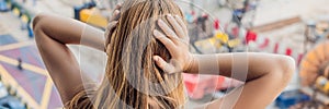 A young woman by the window annoyed by the building works outside. Noise concept BANNER long format