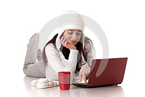 Young woman in winter clothes with laptop