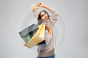 Young woman in winter hat with shopping bags