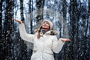 Young woman in a winter park in snowfall