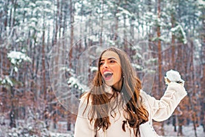 Young woman winter portrait. Models having fun in winter park. Portrait of a beautiful woman dressed a coat.