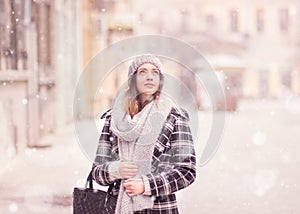 Young woman winter snowing looking above