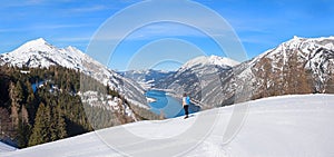 Young woman at wintry hiking trail zwolferkopf mountain, lookout to lake Achensee, tirolean landscape