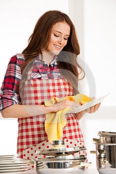 Young woman wipes a pot isolated over white background