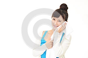 Young woman wiping her face with a towel