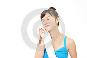 Young woman wiping her face with a towel