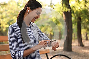 Young woman with wireless earphones and smart watch