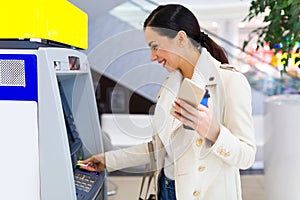 Woman withdrawing cash at an ATM photo