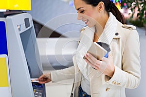 Woman withdrawing cash at an ATM photo