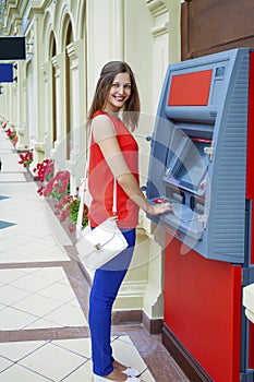 Young woman withdrawing money from credit card at ATM