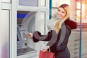 Young woman withdrawing money from credit card at ATM cash machine