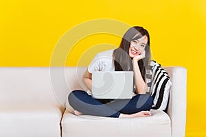 Young woman work from home she sitting on sofa using laptop computer in house