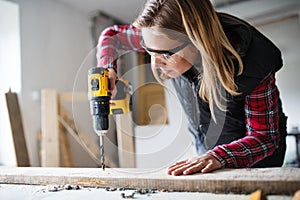 Young woman worker in the carpenter workroom.