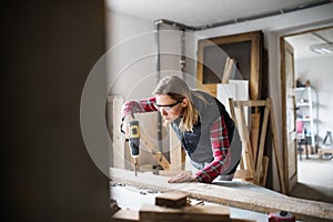 Young woman worker in the carpenter workroom.