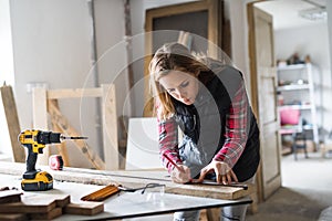 Young woman worker in the carpenter workroom. photo