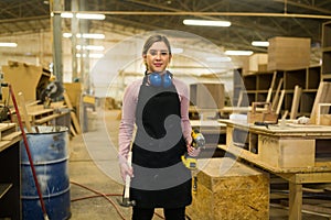 Young woman working as a carpenter in a woodshop photo
