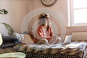 Young woman working in bed at home with laptop