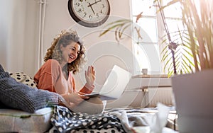Young woman working in bed at home with laptop