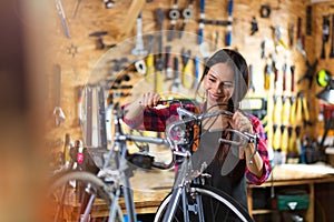 Young woman working in a bicycle repair shop