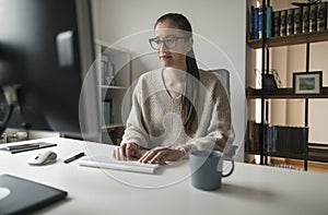 Young woman working on computer from her home