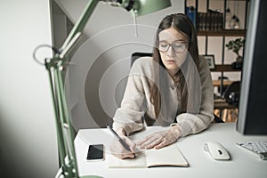 Young woman working on computer at her home office