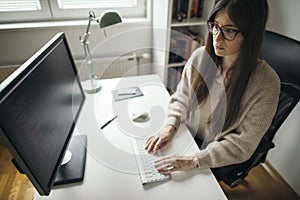 Young woman working on computer from home office