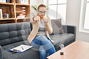 Young woman working at consultation office punching fist to fight, aggressive and angry attack, threat and violence