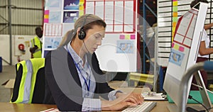 Young woman working at a desk in a warehouse 4k