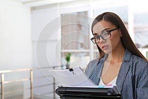 Young woman working with documents in office