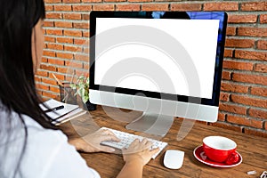 young woman working empty screen computer on wood desk in home office. with clipping path