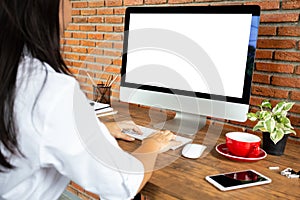 young woman working empty screen computer on wood desk in home office. with clipping path