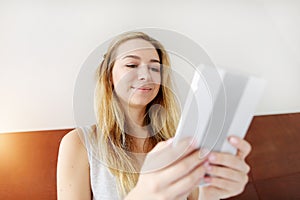 Young woman working happy with tablet at white bed