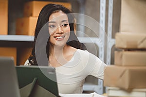 Young woman working at home for packeting parcel boxes to shipping delivery services to customer