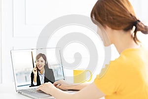 Young woman working at home and using laptop computer with video chat