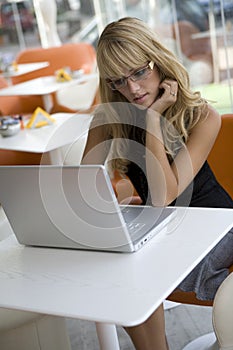 Young woman working with a laptop in a cafe